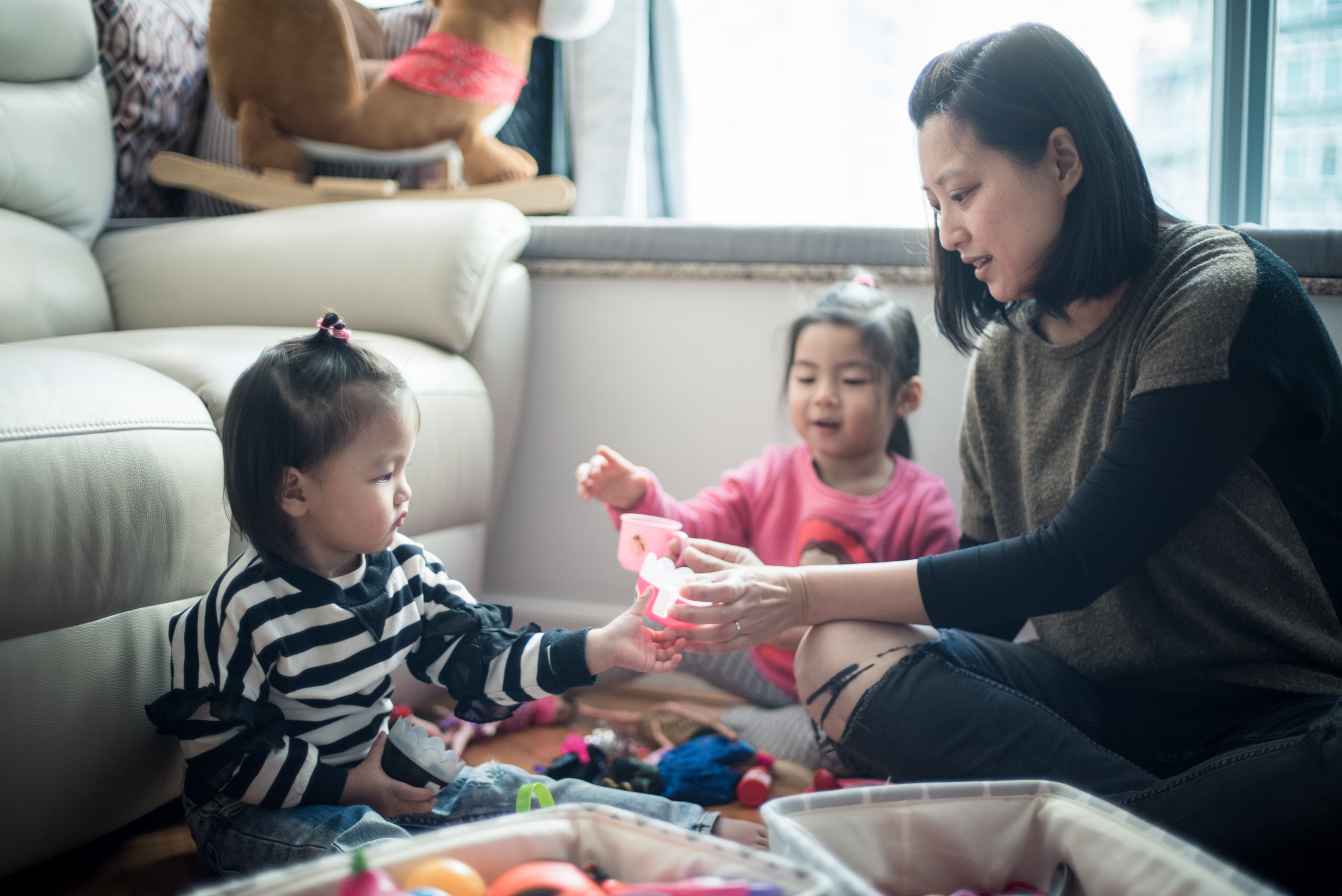 兩名孩子正在與媽媽玩遊戲。