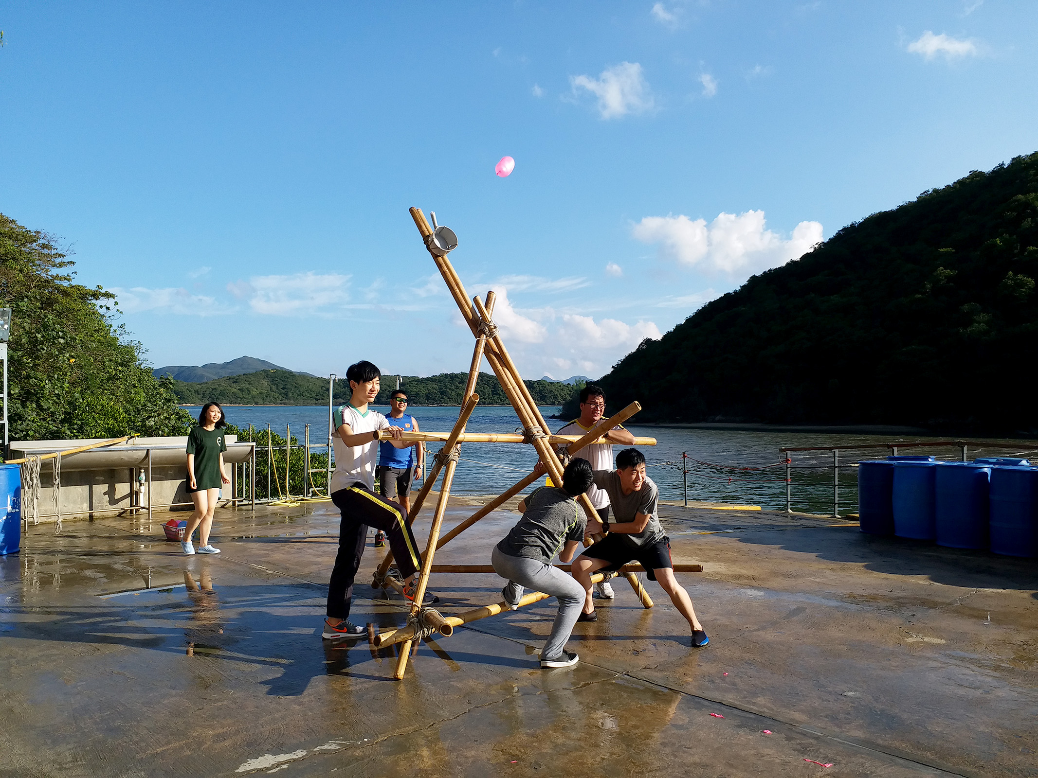 幾個青少年在互相合作，在沙灘上建立建築。